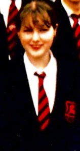 Me (Claire Cherry) aged 15 in a black school uniform with a white shirt and a red and black striped tie