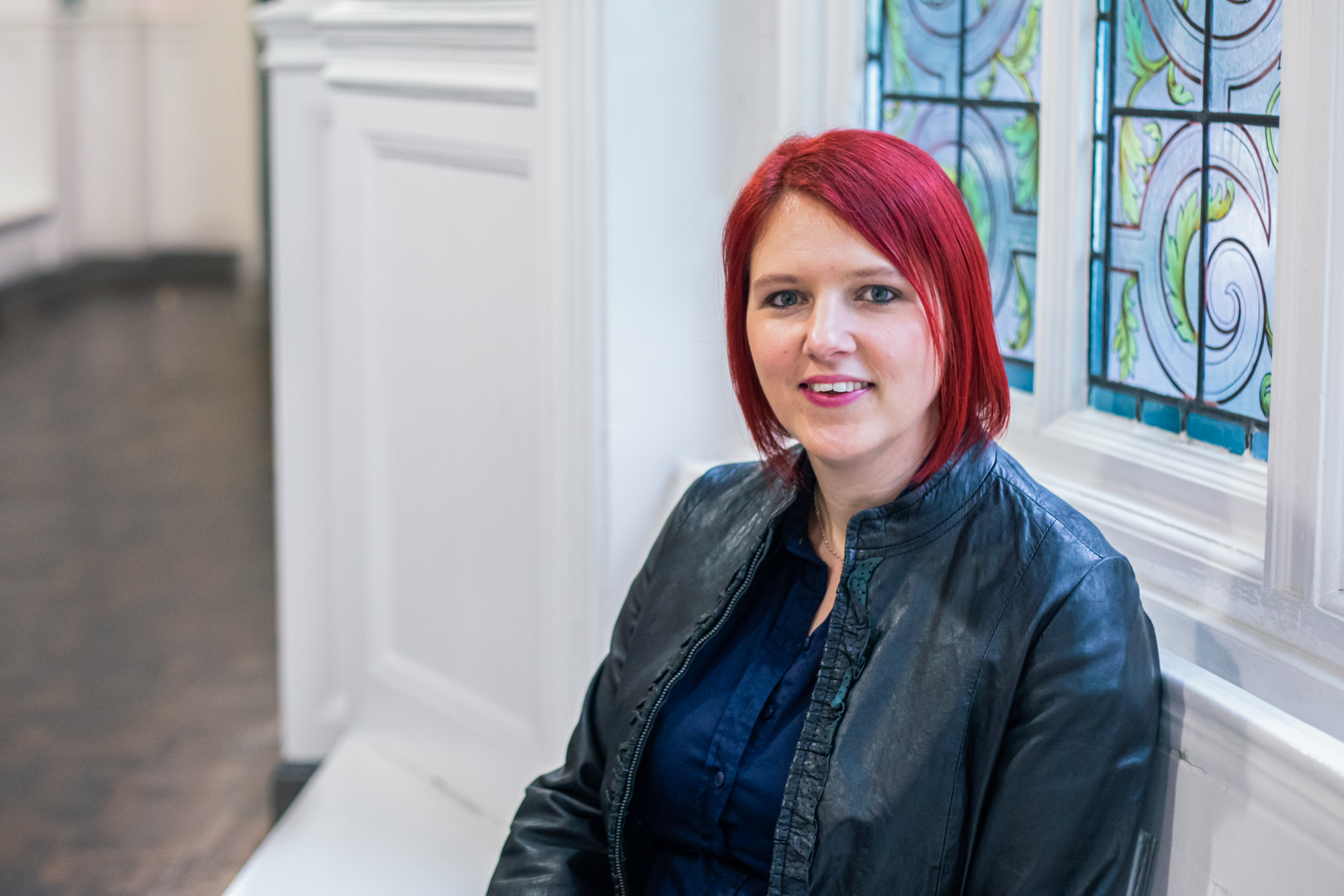 Claire Cronshaw Cherry Edits sitting in front of a stained glass window